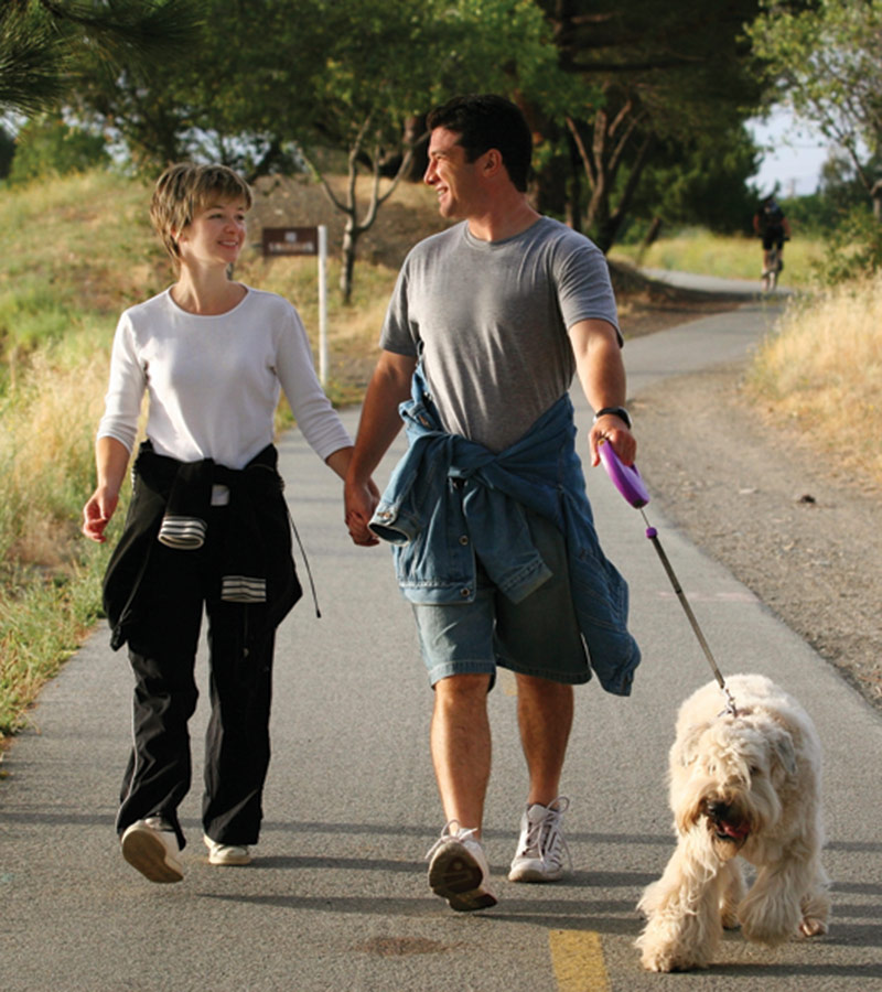A couple walking with a white dog